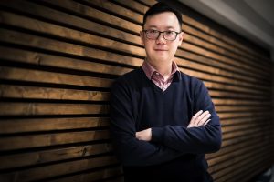 Composer Kevin Lau, resting against a wall